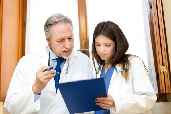 Retrato de um médico e seu assistente em seu estúdio — Fotografia de Stock