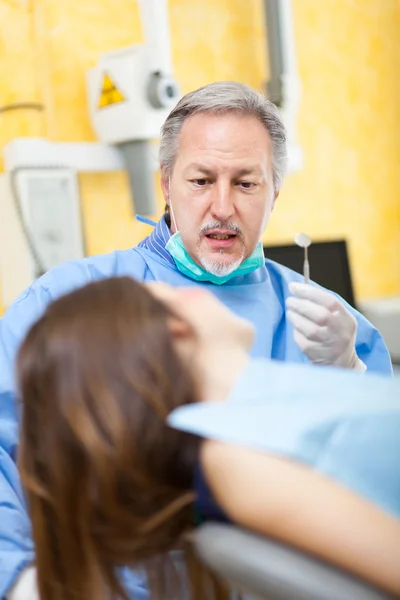 Dentista che effettua un trattamento dentale su una paziente di sesso femminile — Foto Stock