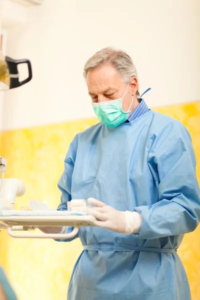 Porträt eines Zahnarztes bei der Überprüfung seiner Werkzeuge — Stockfoto