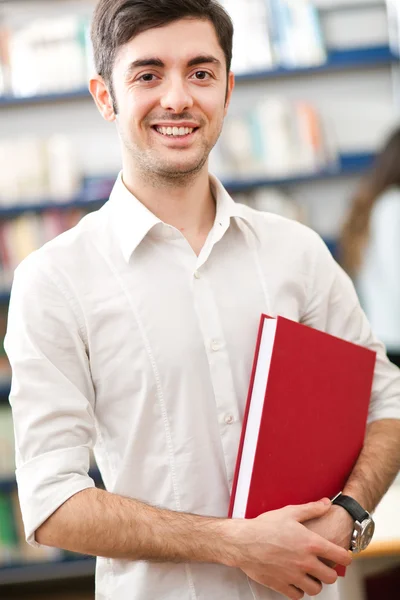 Estudiante masculino de pie en una biblioteca —  Fotos de Stock