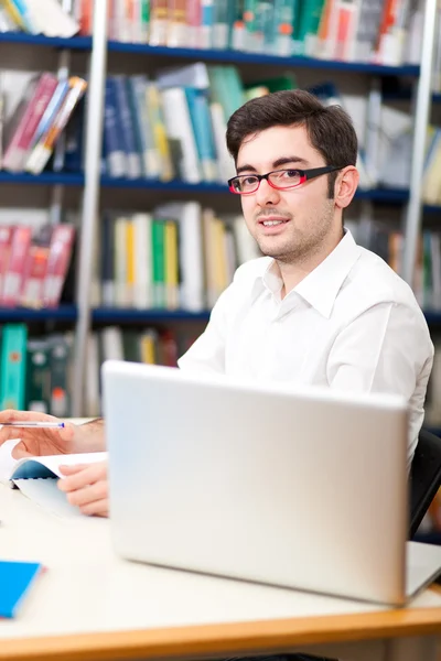 Giovane studente in una biblioteca — Foto Stock