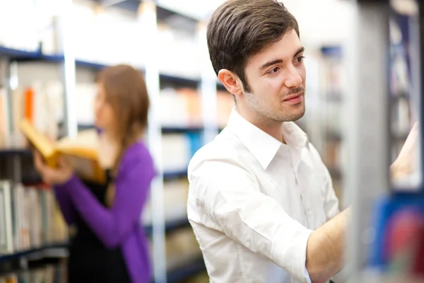 Menschen, die Bücher in einer Bibliothek auswählen — Stockfoto