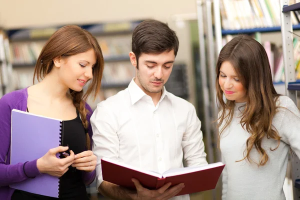 Grupp elever står i ett bibliotek — Stockfoto