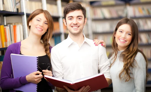 Groep studenten permanent in een bibliotheek — Stockfoto