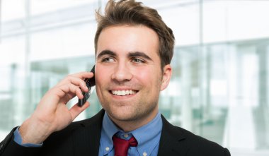 Yakışıklı iş adamı telefonda konuşuyor.