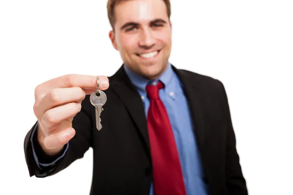 Homem de negócios sorrindo dando chaves para você . — Fotografia de Stock