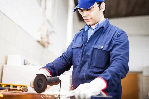 Worker grinding a metal plate — Stock Photo, Image