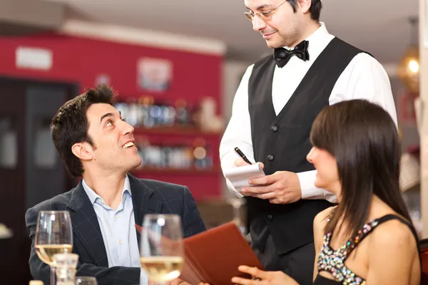 Couple ordering dinner in a restaurant — Stock Photo, Image