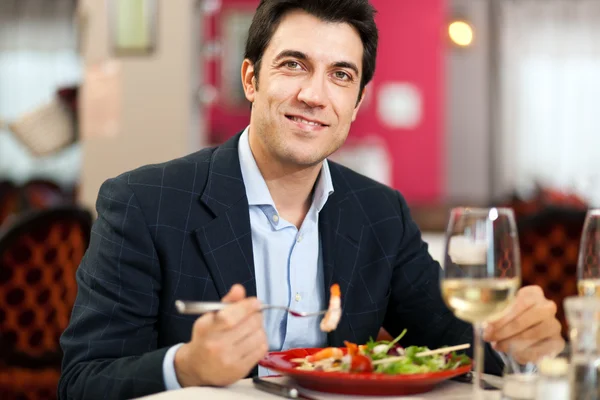 Schöner Mann beim Essen im Restaurant — Stockfoto