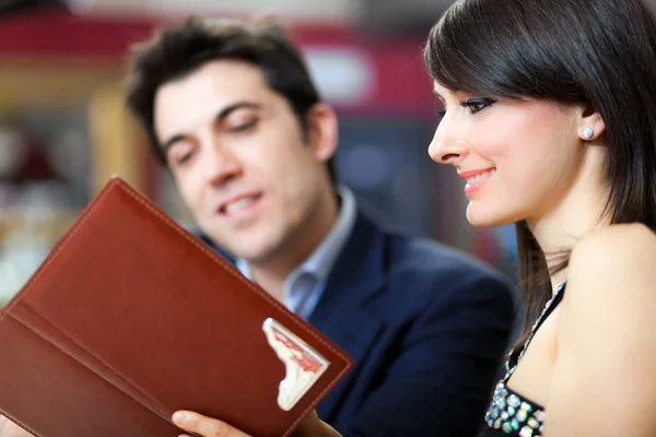 Casal lendo um menu no restaurante — Fotografia de Stock