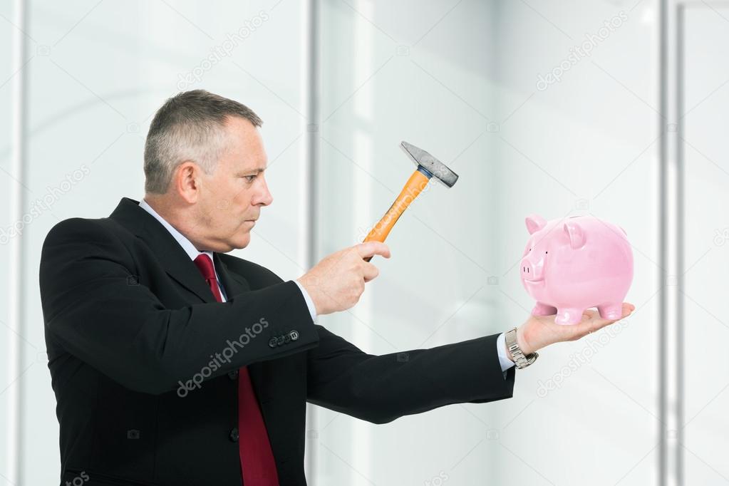 Man breaking a piggy bank