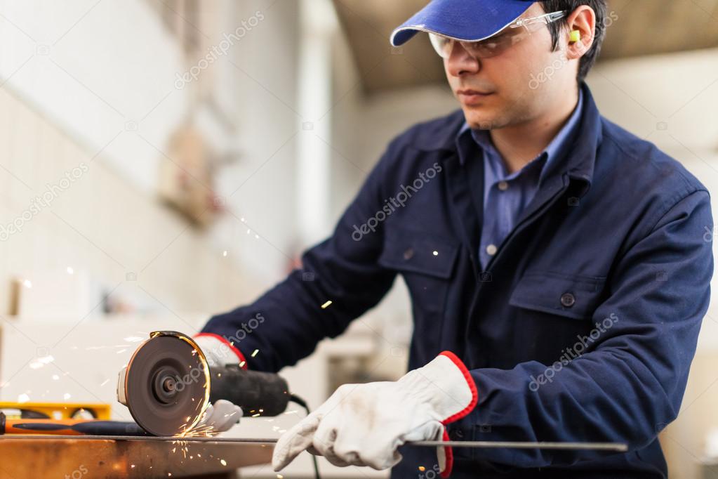 Worker grinding a metal plate