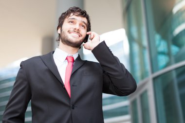 Yakışıklı iş adamı telefonda konuşuyor.