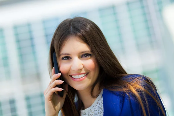 Ung forretningskvinne på telefon i et bymiljø – stockfoto