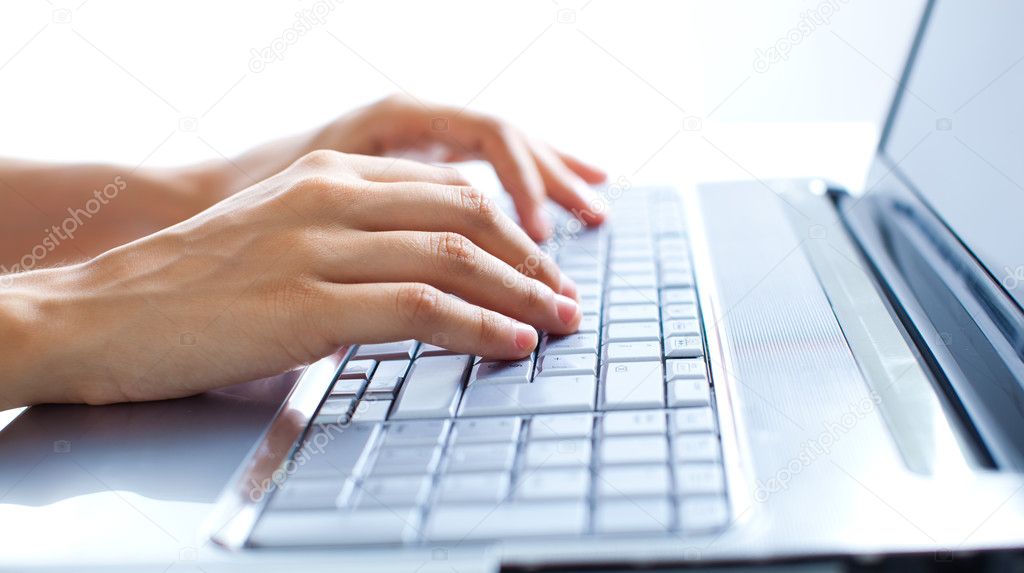 Female hands typing on a laptop