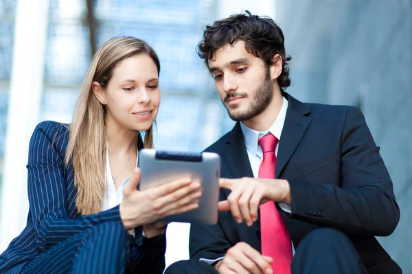 Mensen uit het bedrijfsleven met behulp van een digitale tablet op een trap — Stockfoto