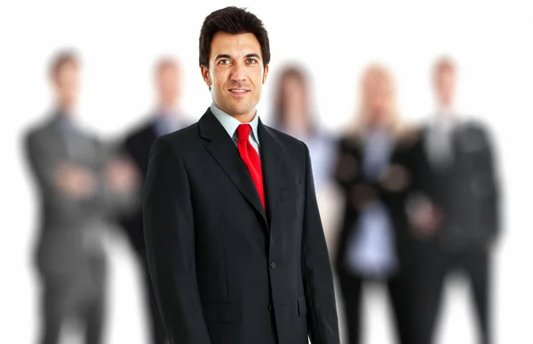 Retrato de un hombre de negocios sonriente frente a su equipo — Foto de Stock