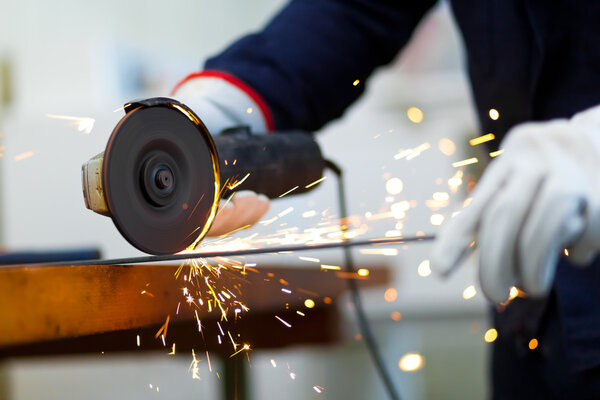 Worker grinding a metal plate