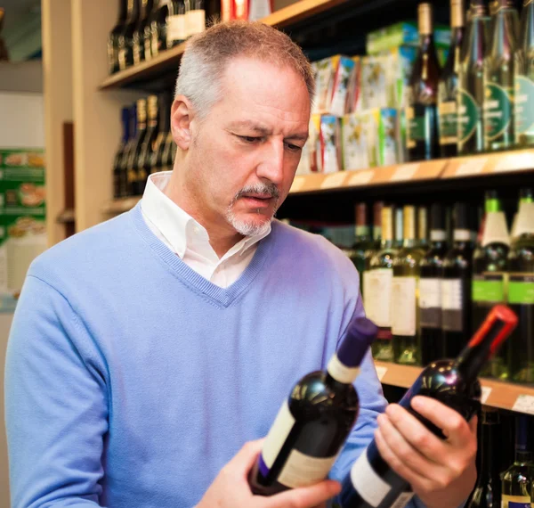 Homem escolhendo vinho — Fotografia de Stock