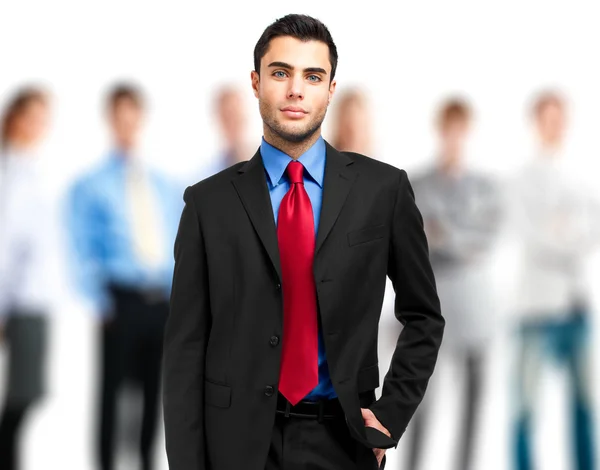 Retrato de un hombre de negocios sonriente frente a su equipo — Foto de Stock