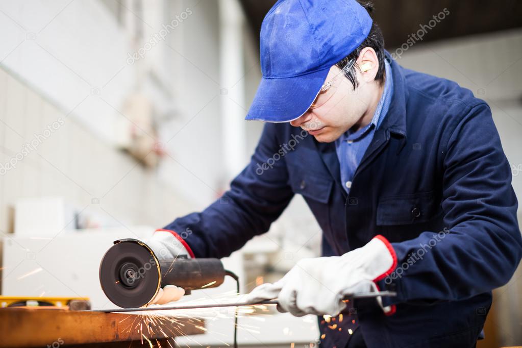 Worker grinding a metal plate