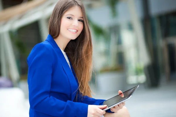 Femme souriante utilisant une tablette numérique — Photo