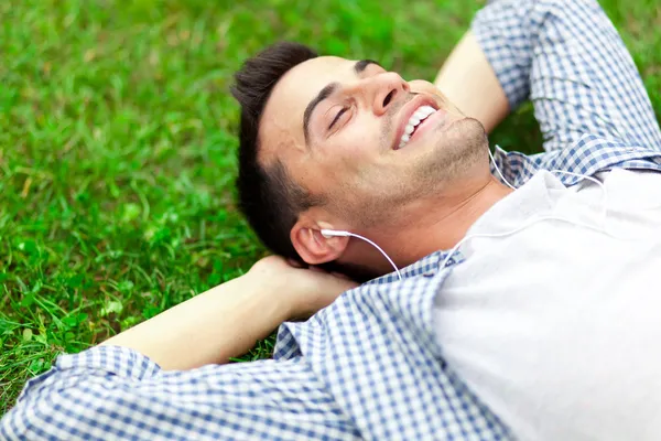 Fiatal ember pihen a fűben — Stock Fotó
