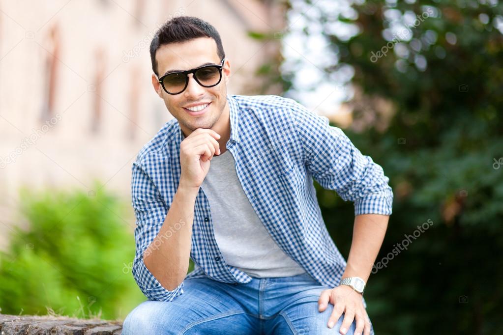 Man posing outdoors with sunglasses