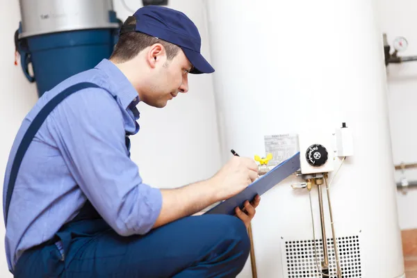 Technician servicing an hot-water heater — Stock Photo, Image