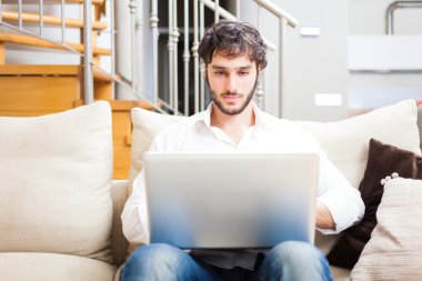 dairesinde bir dizüstü bilgisayar kullanan adam