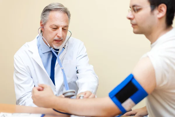 Arzt überprüft Blutdruck — Stockfoto