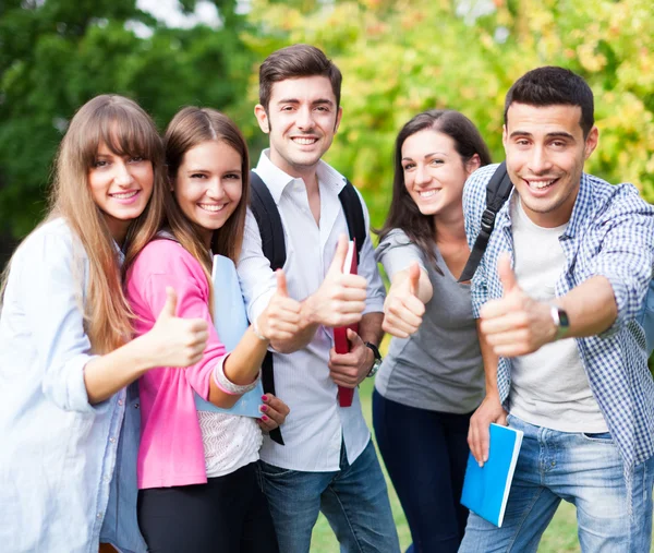 Grupp glada studenter med tummen upp — Stockfoto