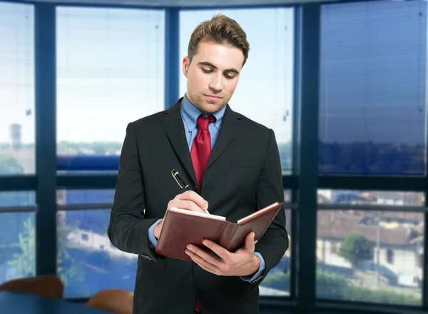 Mann schreibt auf seine Agenda — Stockfoto