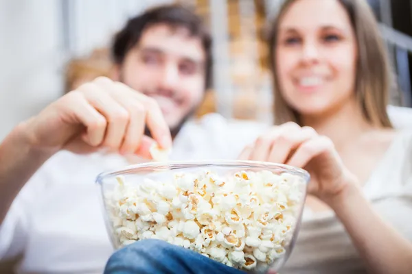 Pareja comiendo palomitas mientras ve una película — Foto de Stock