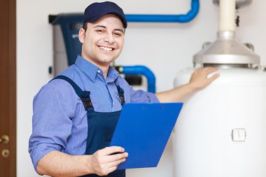 Smiling technician servicing an hot-water heater clipart