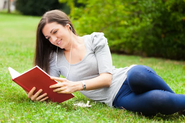 Kvinna läser en bok i en park — Stockfoto