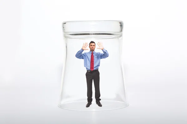 Empresario bajo un vaso — Foto de Stock