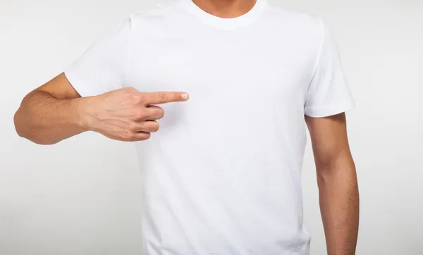 Homem apontando o dedo em uma camiseta em branco — Fotografia de Stock