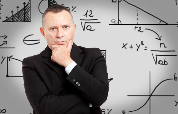 Business man with formulas on background — Stock Photo, Image