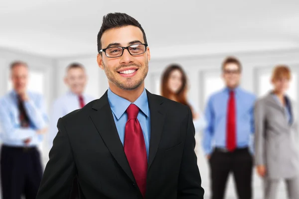 Empresário com equipe em segundo plano — Fotografia de Stock