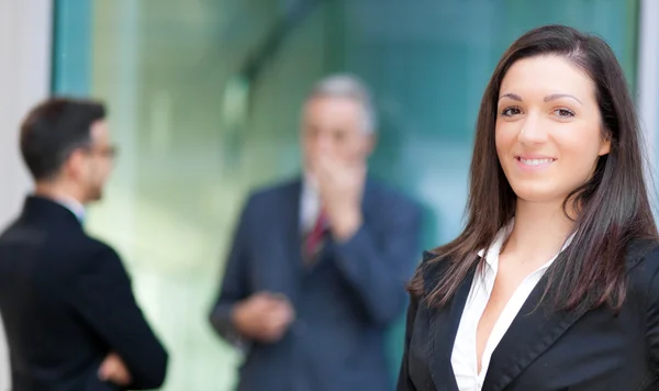 Mujer de negocios en el frente de sus socios —  Fotos de Stock