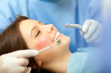 Dentist doing a dental treatment clipart