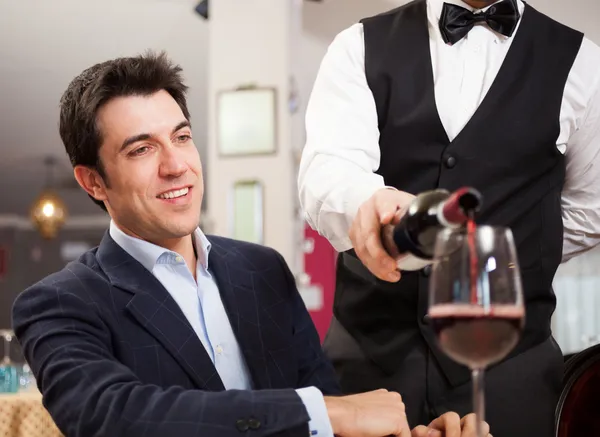 Kellner schenkt Wein ein — Stockfoto