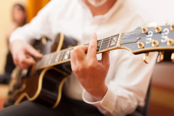 Guitarist playing an acoustic guitar — Stock Photo, Image