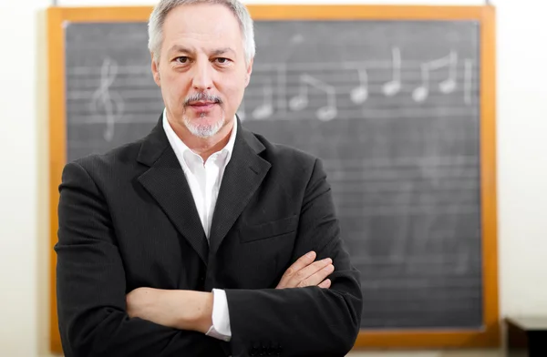 Teacher in front of chalkboard with a note — Stock Photo, Image