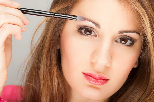 Mujer aplicando sombra de ojos — Foto de Stock