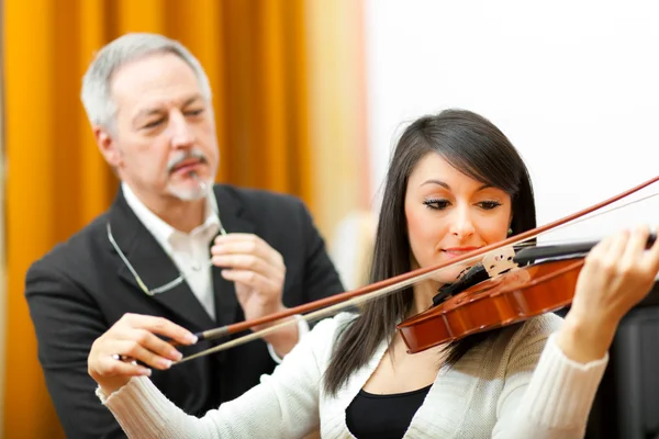 Geigenlehrerin hilft einem Schüler — Stockfoto