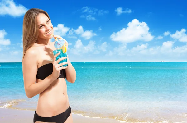 Mujer bebiendo un cóctel en la playa — Foto de Stock