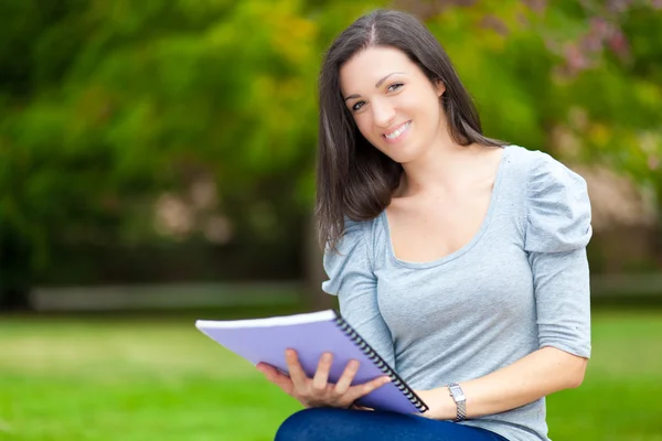 Student reading a book in a park — Stock Photo, Image