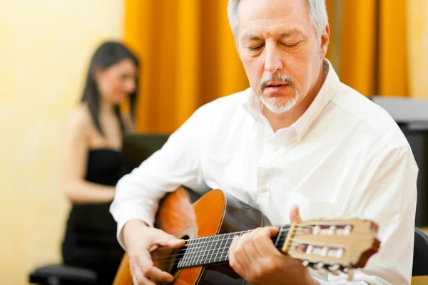 Homme mûr jouant une guitare classique — Photo